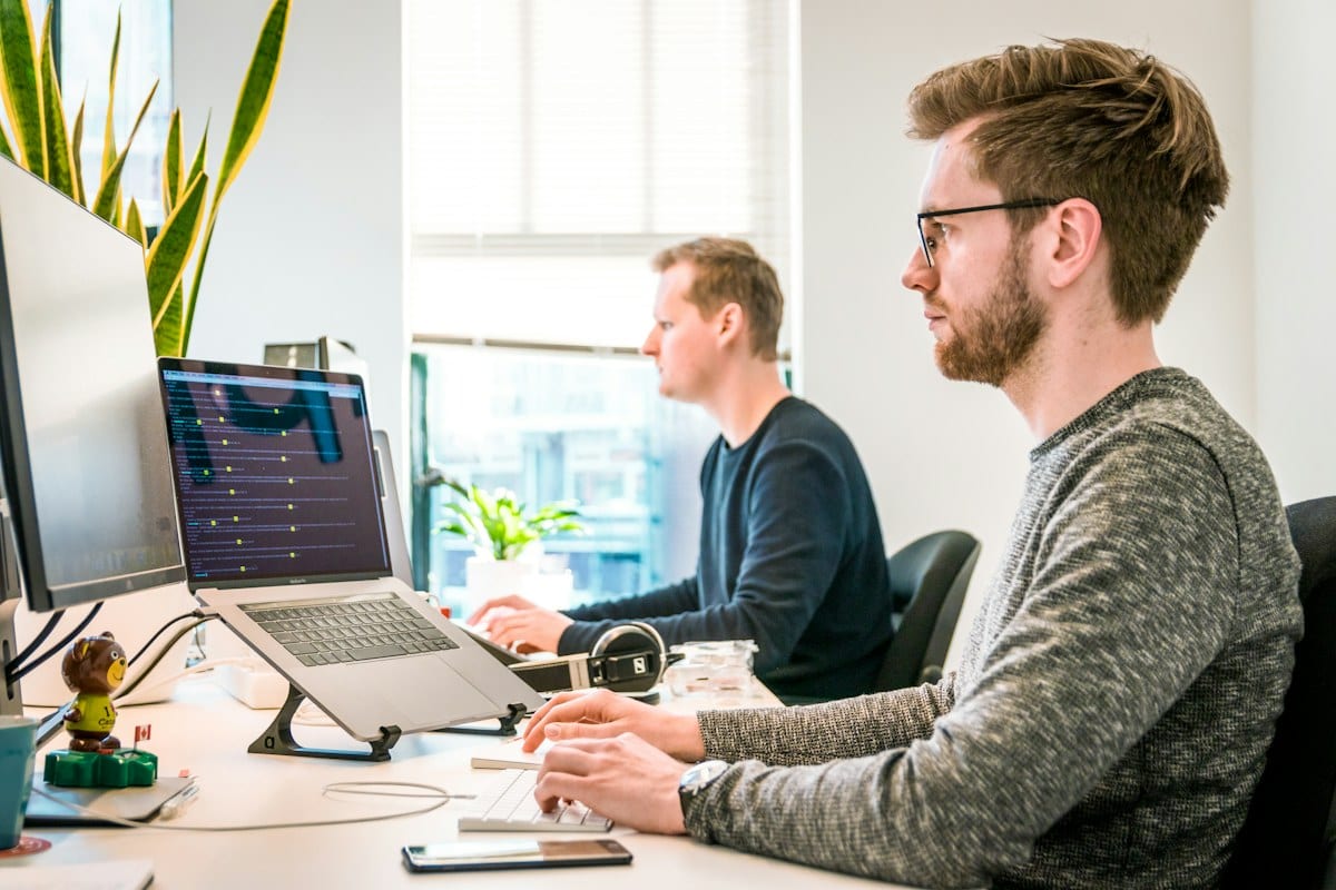 Developers pairing on code at a shared desk