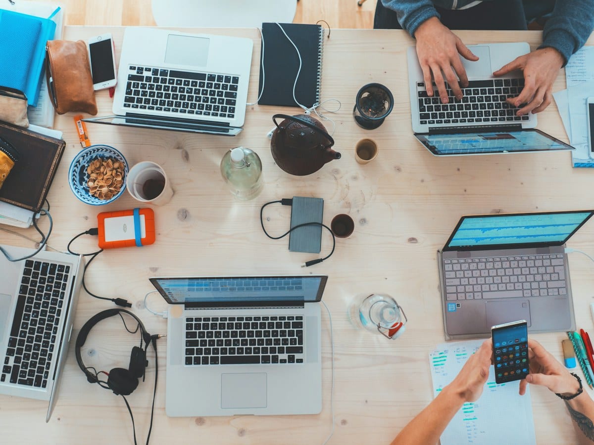 People working on laptops around a table